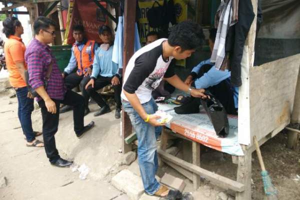 Aparat Polres Tangsel memeriksa tas pelaku pungli di Jalan Raya Legok. (ist)